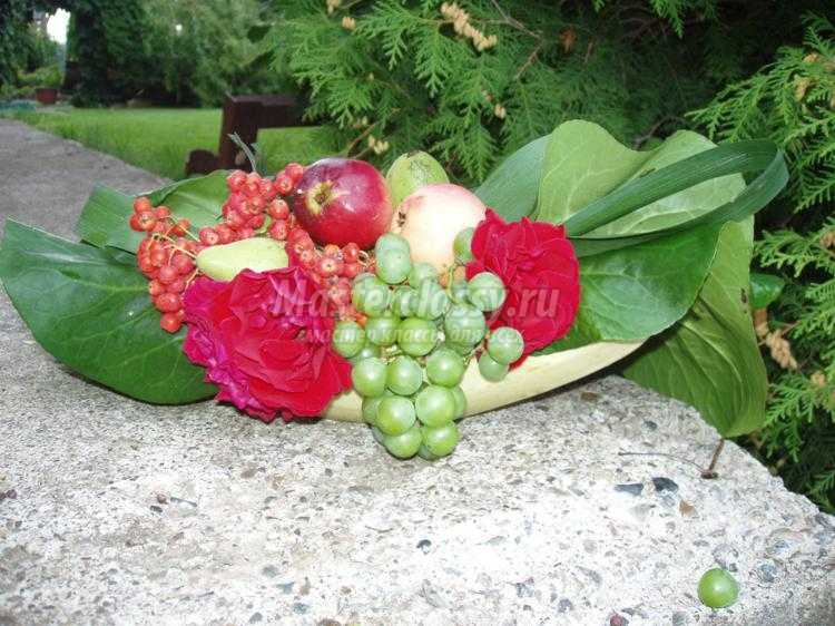 Осенняя флористическая композиция из цветов, ягод и фруктов.